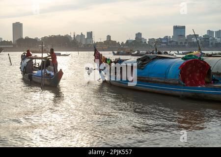 Phnom Penh,Cambodge-24 décembre 2022:les petits bateaux étroits, partiellement couverts contre les éléments et utilisés comme logement par les familles khmères, s'assoient sur le moins Banque D'Images