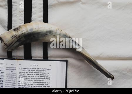 07-07-2022. jérusalem-israël. Un livre de prière pour la fête juive de Rosh Hashanah - ouvert et placé sur un tallite à rayures noires, à côté d'un shofar ma Banque D'Images