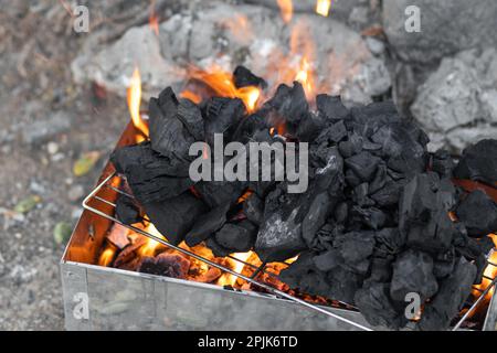 Des charbons brûlants à l'intérieur d'un barbecue - arrière-plan flou Banque D'Images