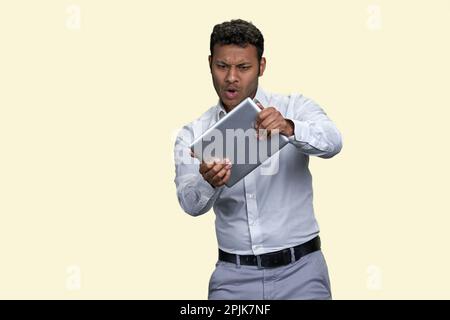 Portrait d'un jeune indien jouant au jeu avec une tablette. Isolé sur fond blanc. Banque D'Images