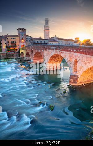 Vérone, Italie. Image de paysage urbain de la belle ville italienne de Vérone avec le pont de pierre au-dessus de la rivière Adige au coucher du soleil. Banque D'Images