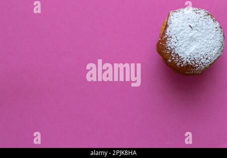 Donut Hanukkah, enrobé de sucre en poudre. sur fond rose Banque D'Images