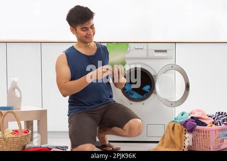 Portrait d'un jeune homme qui fait du linge Banque D'Images