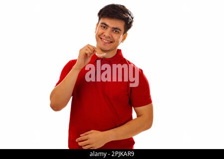 Jeune homme souriant tenant les dents d'alignement sur fond blanc Banque D'Images