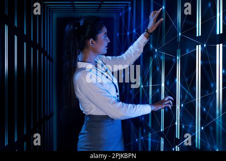 Femme technicien/programmeur travaillant sur le serveur dans la salle de stockage des données Banque D'Images