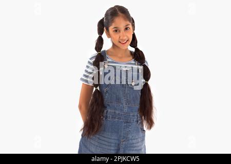 Tween fille avec des cheveux tressés debout sur fond blanc Banque D'Images