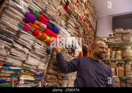 Fournisseur de tissu masculin montrant la bordure et la dentelle à un acheteur Banque D'Images