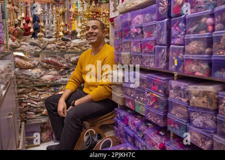 Portrait d'un homme de magasin gai assis à son magasin de latkan et de testicules Banque D'Images