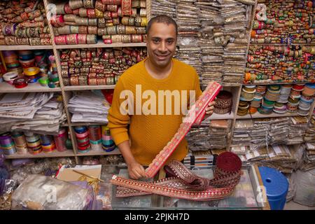 Portrait d'un homme de magasin gai debout à sa boutique de dentelle Banque D'Images