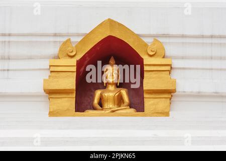 Laos, Luang Prabang. Petite statue de Bouddha dans la niche dans le mur du temple. Banque D'Images
