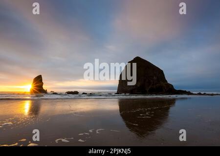 États-Unis, Oregon. Cannon Beach et Haystack Rock au coucher du soleil Banque D'Images