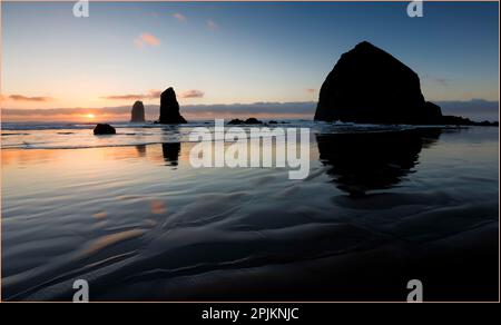 États-Unis, Oregon. Cannon Beach et Haystack Rock au coucher du soleil Banque D'Images