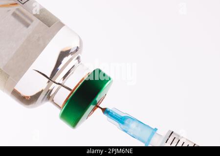 Remplissage de la seringue à partir d'un flacon de liquide clair tel que l'insuline, sur fond blanc avec espace de copie Banque D'Images