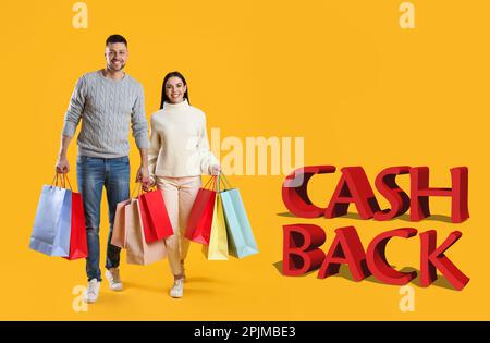 Couple heureux avec des sacs d'achats et des mots Cash Back sur fond jaune Banque D'Images