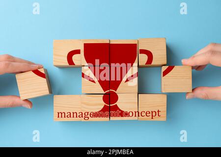 Vue de dessus des personnes et des cubes en bois avec image de la tasse sur fond bleu clair Banque D'Images