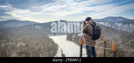 La photo capture la beauté sereine de la rivière Mana gelée dans le Mana Loop de Sibérie, tandis qu'un photographe de voyage prend dans le paysage d'hiver étonnant de t Banque D'Images