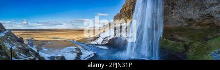 Vue sur Seljalandsfoss depuis l'intérieur de la cascade lors d'une belle journée d'hiver, en Islande. Banque D'Images