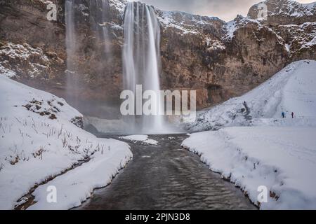 Vue sur Seljalandsfoss depuis l'intérieur de la cascade lors d'une belle journée d'hiver, en Islande. Banque D'Images