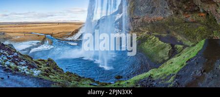 Vue sur Seljalandsfoss depuis l'intérieur de la cascade lors d'une belle journée d'hiver, en Islande. Banque D'Images