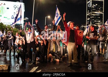 Les manifestants contre le chant des réformes se lèvent et se lèvent la main après avoir été pulvérisés par un canon à eau de la police sur l'autoroute Ayakon bloquée de tel Aviv. Plus de 220 000 ont protesté contre le gouvernement d’extrême droite de Netanyahou et contre sa réforme juridique controversée. AVR 01th 2023. (Photo de Matan Golan/Sipa USA). Banque D'Images