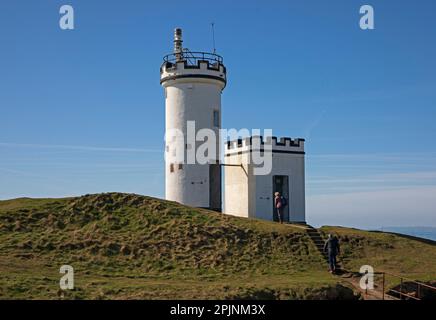 Fife, Écosse, Royaume-Uni. 3rd avril 2023. Le soleil et le ciel bleu avec de belles vues pittoresques auraient pu faire croire aux visiteurs qu'ils étaient dans le sud de la France au lieu de sur la côte de Fife, bien qu'après moins de températures pendant la nuit et la température en milieu de matinée à 8 degrés centigrades et se réchauffant jusqu'à un peu plus de 10 degrés dans l'après-midi peut-être qu'il était légèrement plus frais que le continent. Photo : un couple qui monte vers le phare d'Elie Ness qui est situé le Neuk est de Fife sur le promontoire entre Inchkeith et l'île de Mai. Credit: Archwhite/alamy Live news. Banque D'Images