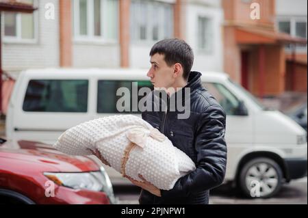 Un homme tient un enfant enveloppé dans une couverture. Père tenant son fils dans ses bras. Banque D'Images