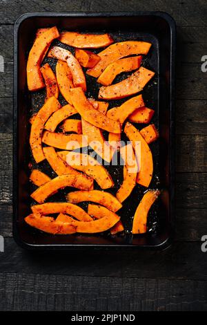 Tranches de citrouille avec épices sur une plaque à pâtisserie. Banque D'Images