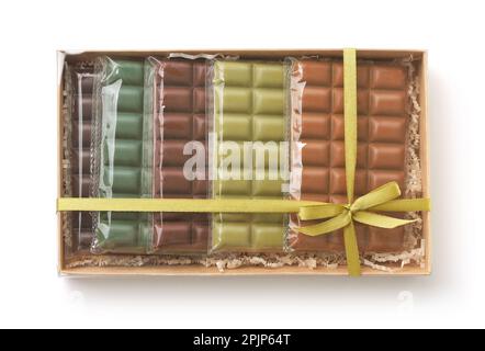 Vue de dessus de diverses barres de chocolat colorées dans une boîte-cadeau en papier isolée sur blanc Banque D'Images