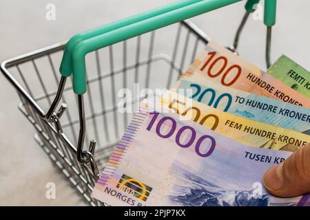Monnaie norvégienne avec un panier vide, concept, hausse des prix dans les magasins, achats de plus en plus chers, inflation en Norvège, affaires et fina Banque D'Images