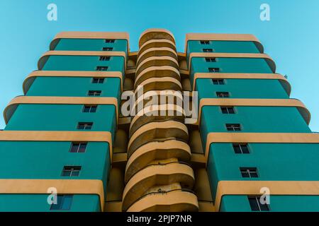 Un petit angle de vue d'un grand immeuble d'appartements vert, montrant l'architecture moderne et élégante Banque D'Images