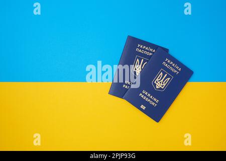 Deux passeports biométriques bleus ukrainiens sur le drapeau national ukrainien dans la vue de dessus Banque D'Images