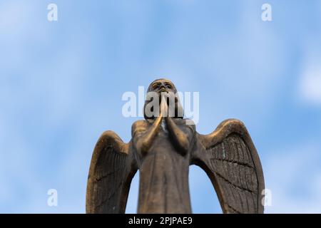 Détail de la magnifique statue en bronze d'un ange avec des ailes contre le ciel. Bel ange avec un fond bleu ciel avec espace pour le texte, gros plan Banque D'Images