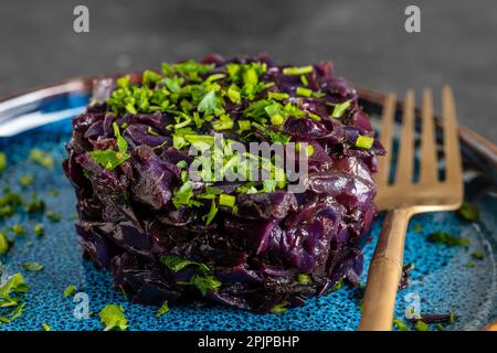 Chou rouge frit cuit dans du vin chaud servi dans une assiette. Fond de chou bleu frit, macro. Gros plan Banque D'Images