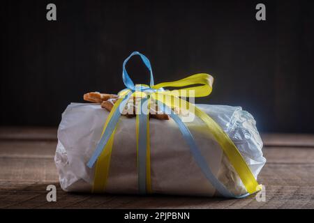 Noël en papier blanc avec ruban jaune et bleu pour un cadeau de Noël, pain allemand traditionnel pour un dessert de pâtisserie festif. Clos Banque D'Images