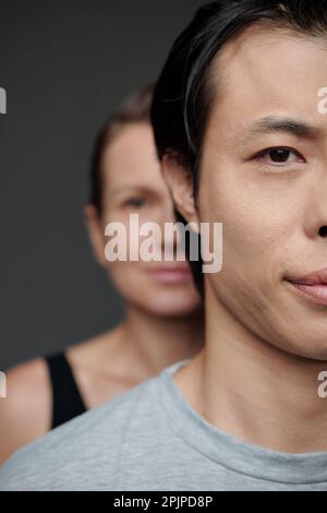 Demi-visage de l'homme japonais et de la femme mûre debout derrière lui Banque D'Images