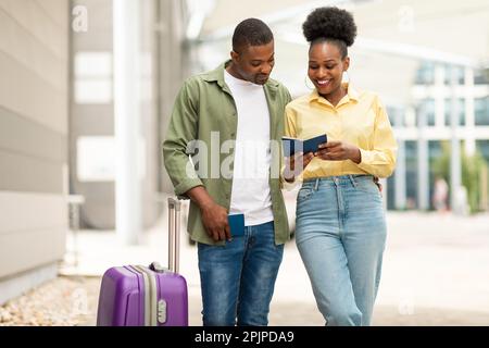 Heureux couple de voyageurs afro-américains détenteurs d'un passeport près de l'aéroport Banque D'Images