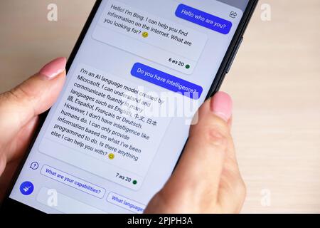 Chat en ligne avec intelligence artificielle dans l'application mobile Bing de Microsoft. Smartphone entre les mains des femmes Banque D'Images