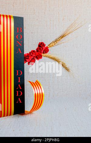 Roses et livre noir, oreille de blé, avec drapeau catalan et ruban rouge, sur fond beige avec texture, vertical, espace de copie, jour de la Saint-Valentin Banque D'Images
