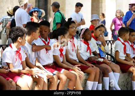 Les enfants des écoles cubaines des pionniers assis dans la rue de la ville pendant l'excursion Banque D'Images