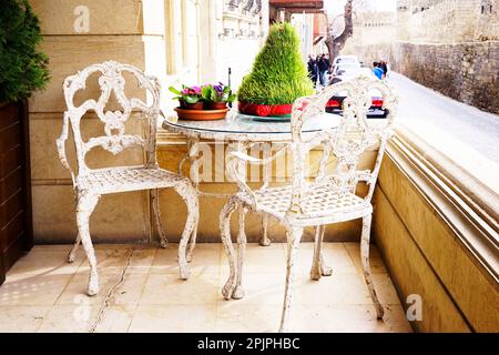 Mobilier de jardin blanc vintage en fer forgé, ensemble de table ronde vide et deux chaises élégantes sur le balcon. Attention sélective sur les meubles, personne Banque D'Images