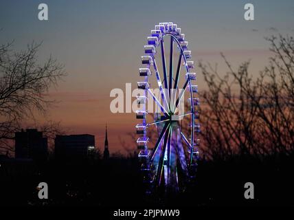 Hambourg, Allemagne. 03rd avril 2023. La grande roue du Hamburg Spring Dome, sur le Heiligengeistfeld, est illuminée en couleurs. Credit: Marcus Brandt/dpa/Alay Live News Banque D'Images