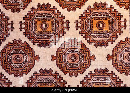 Moquette en soie artisanale colorée avec motifs dans des tons rouges, style traditionnel ouzbek. Gros plan. Banque D'Images