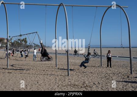 Santa Monica, Californie, États-Unis. 26th mars 2023. Les amateurs de plage se balancent dans les bars à singes de l'ancienne plage de muscle Beach.Santa Monica Beach est une attraction populaire en Californie avec plus de 3 kilomètres de large plage de sable, parfaite pour nager, bronzer, surf, et Beach volley. La plage est entourée de palmiers, de la célèbre jetée de Santa Monica, de vélos en location et de nombreux restaurants avec vue imprenable sur le coucher du soleil. (Credit image: © Taidgh Barron/ZUMA Press Wire) USAGE ÉDITORIAL SEULEMENT! Non destiné À un usage commercial ! Banque D'Images