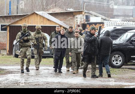 RÉGION DE TCHERNIHIV, UKRAINE - le 03 AVRIL 2023 - le président de l'Ukraine, Volodymyr Zelenskyy (C), visite une école où les occupants russes ont tenu des civils en otage dans le sous-sol, de 3 mars au 30 avril 2022, village Yahidne, région de Tchernihiv, dans le nord de l'Ukraine. Banque D'Images