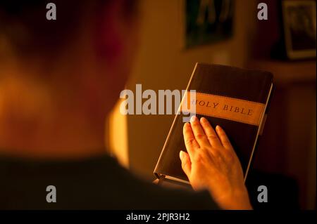 Woman with hand touching Bible Banque D'Images