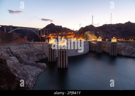 Barrage Hoover au coucher du soleil dans la soirée avec illuminations sans personnes. Barrage Hoover, point de vue. Barrage Hoover et lac Mead dans la région de Las Vegas. Grandes tours d'admission Comstock au barrage Hoover. Banque D'Images