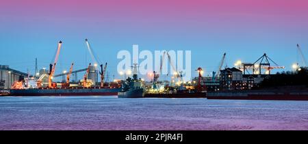 Le port de Tyne s'amarre la nuit avec des navires cargo et de la Marine en présence contre le ciel bleu profond rose de nuit Banque D'Images