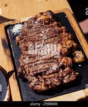 Bifteck de ribeye grillé sur une planche de bois. Viande grillée avec sauce. Banque D'Images