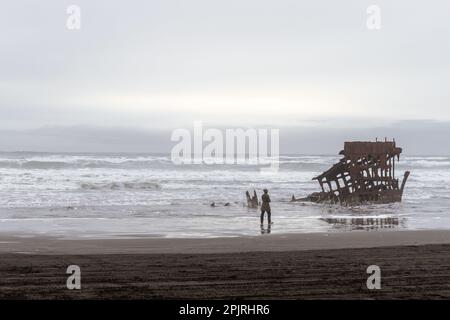 Femme marchant sur la plage à l'épave du Peter Iredale le long de l'océan Pacifique Banque D'Images