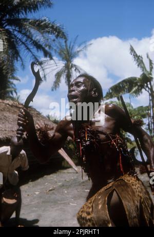 Afrique, République démocratique du Congo, région du fleuve Ngiri. Groupe ethnique Libinza. Deviner dansant, tenant un couteau cérémoniel. Banque D'Images